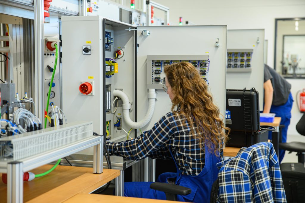 Auszubildende an einem Schaltschrank