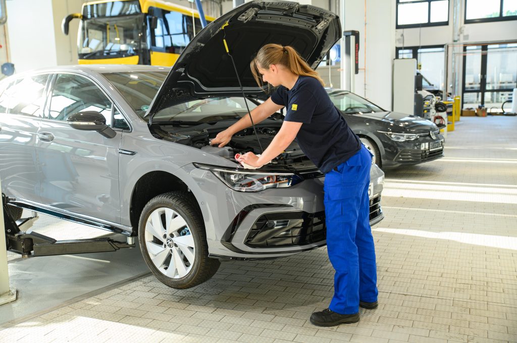 Auszubildende arbeitet am Fahrzeug