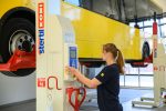 Auszubildende bedient den Radgreifer für Nutzfahrzeuge