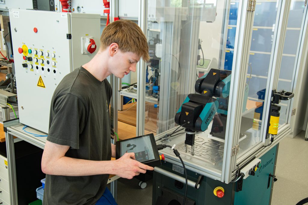 Auszubildender programmiert den Roboter "Horst".